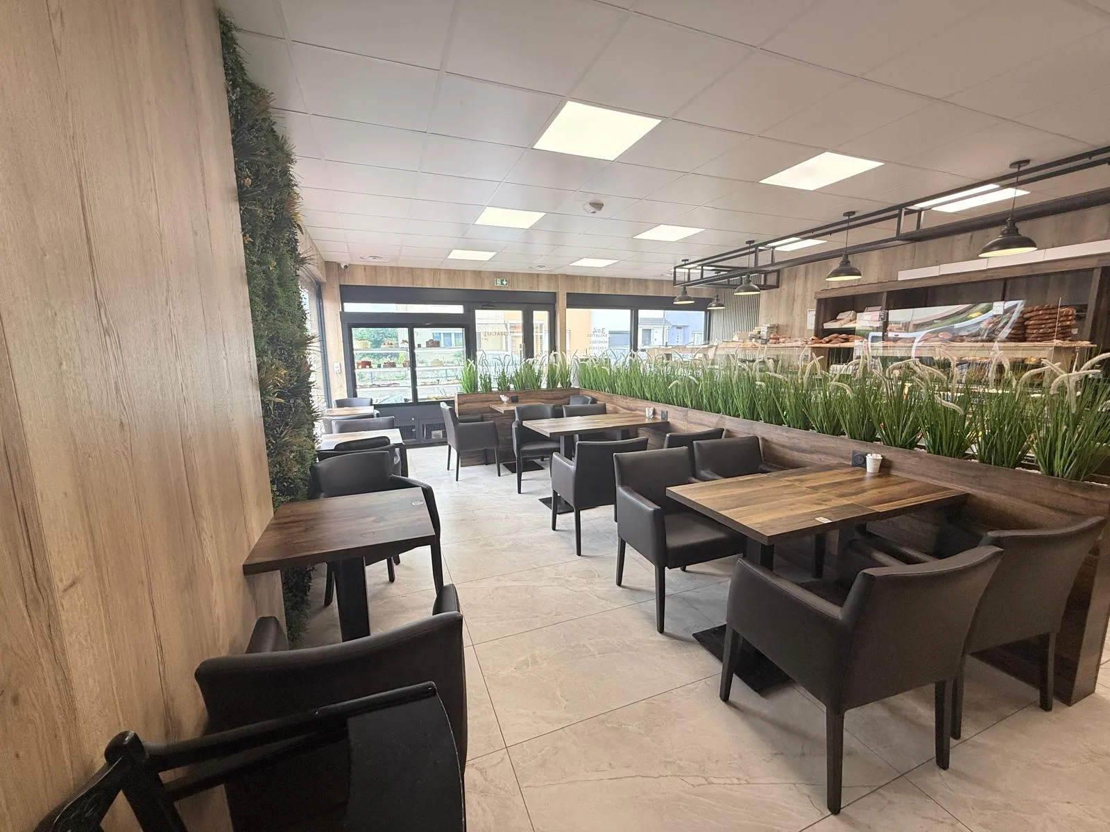 Salle de la boulangerie Simit et Café avec tables et mur végétal